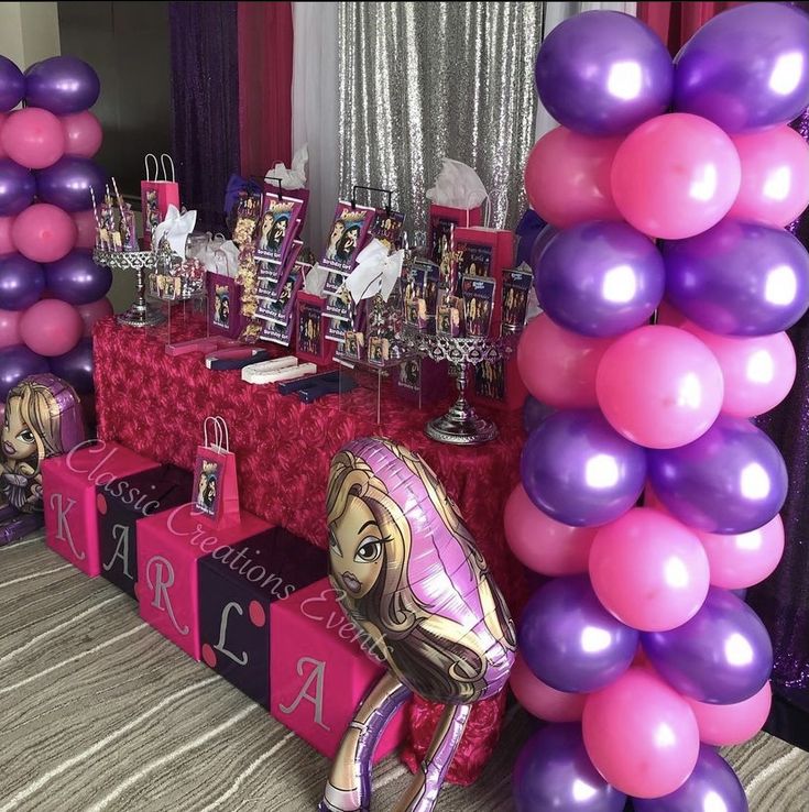 the table is set up with pink and purple balloons