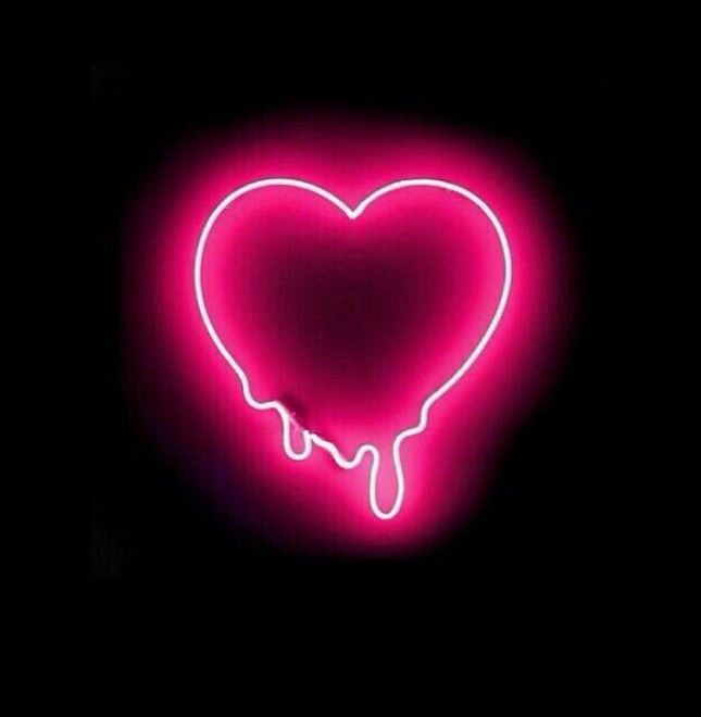 a heart shaped neon sign in the dark with dripping liquid on it's side