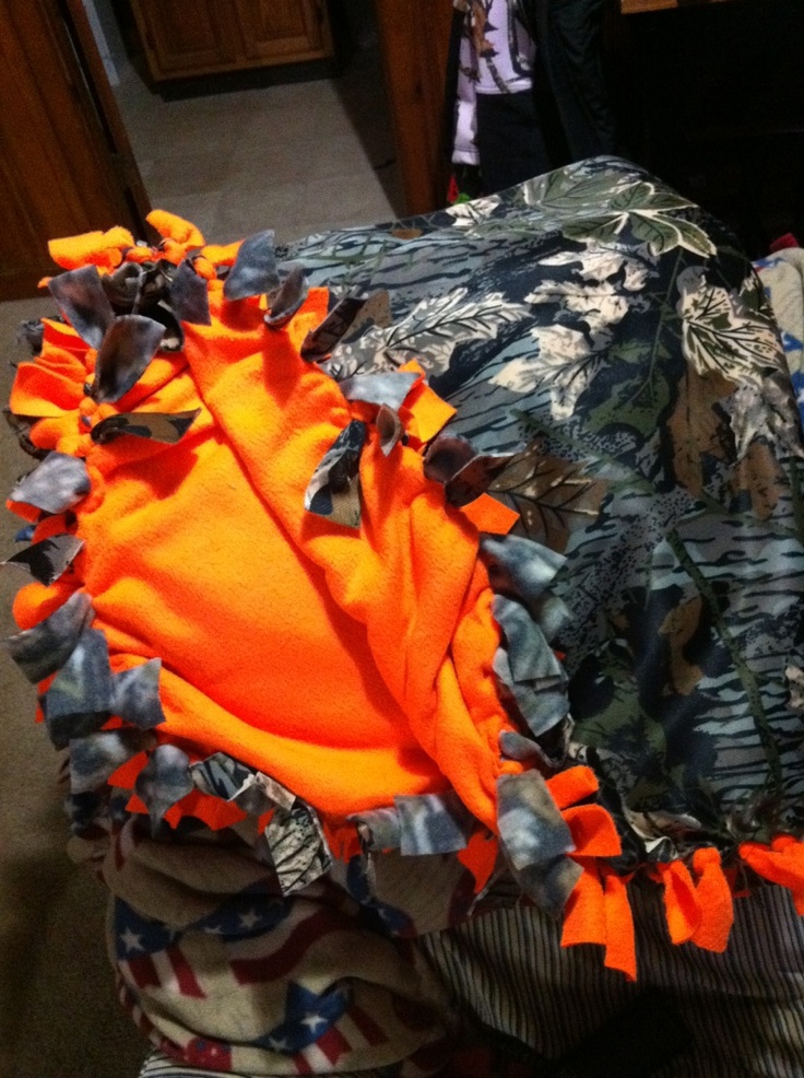 an orange and black object sitting on top of a pile of cloth covered in plastic