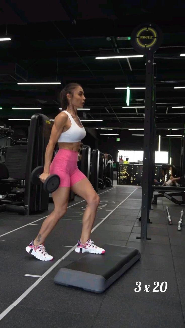 a woman in pink shorts and white top doing exercises on a weight scale