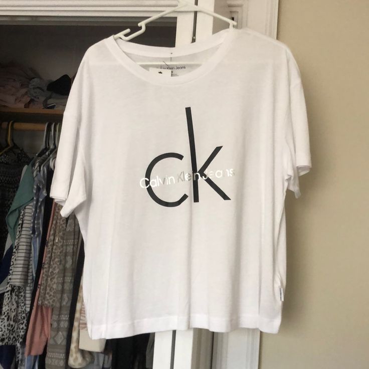 Large Women’s Calvin Klein Cropped T-Shirt White Cropped T-shirt With Logo Print For Spring, Spring White Cropped T-shirt With Logo, Calvin Klein White Logo Print T-shirt, Calvin Klein Relaxed Fit Crew Neck T-shirt, Casual White Cropped T-shirt With Logo Print, Basic Calvin Klein Crew Neck T-shirt, Basic Crew Neck Calvin Klein T-shirt, Trendy Calvin Klein Top With Graphic Print, Calvin Klein Basic Short Sleeve Tops