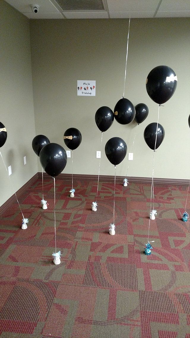 black balloons floating in the air on a carpeted floor