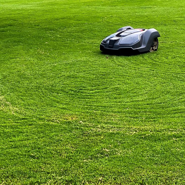 a lawn mower sitting on top of a lush green field