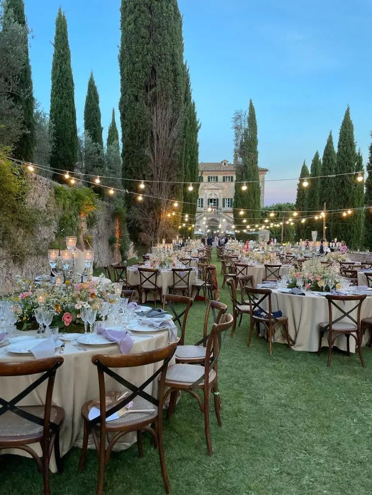 an outdoor dining area with tables and chairs set up for a formal function in the evening