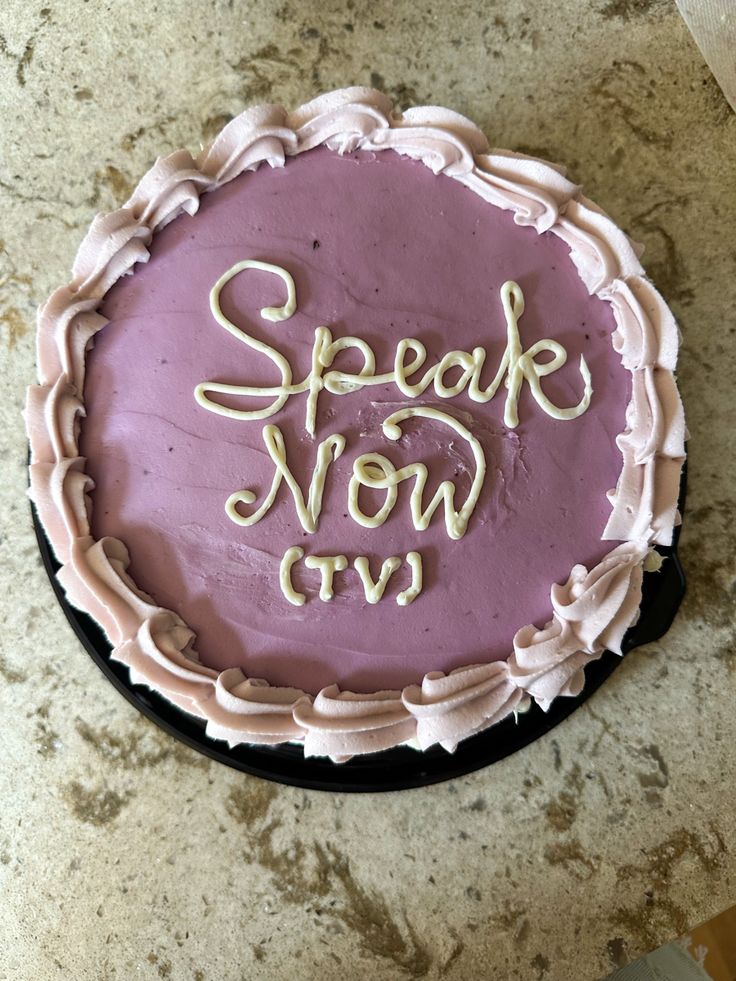 a cake that is on top of a table with words written in white frosting