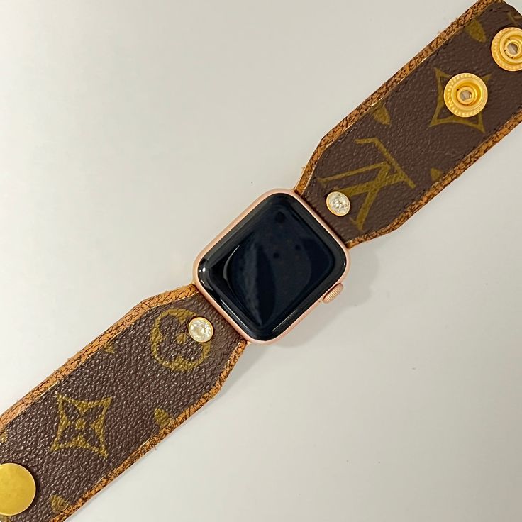 Introducing "Samantha Anne" - a custom-made apple watch band that exudes sophistication and style! Hand-crafted with precision and care, this designer watchband features soft variegated tan/coffee leather, complemented by the classic brown and gold LV monogram material sourced from authentic bags. The band is meticulously secured with gold fitting connectors, ensuring a snug fit for your apple watch. Designed for both adjustability and comfort, two gold high-quality snaps have been incorporated Designer Gold Leather Watch Accessories, Luxury Gold Leather Strap Watch Bands, Luxury Gold Watch Bands With Leather Strap, Adjustable Timeless Bracelet Strap Watch Band, Modern Brown Watch Accessories For Everyday, Trendy Brown Leather Strap Watch Bands, Modern Brown Rectangular Watch Accessories, Luxury Adjustable Apple Watch Band For Gift, Designer Adjustable Brown Bracelet