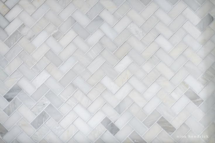 a white tile wall with some gray and white tiles