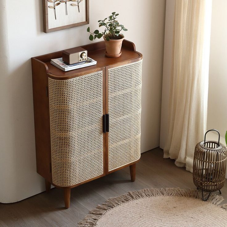 a wicker cabinet with a potted plant on top