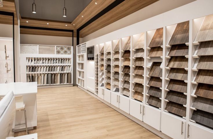 a store with lots of wooden flooring and white shelves filled with different types of wood