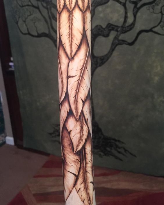 an arm tattoo with feathers on it