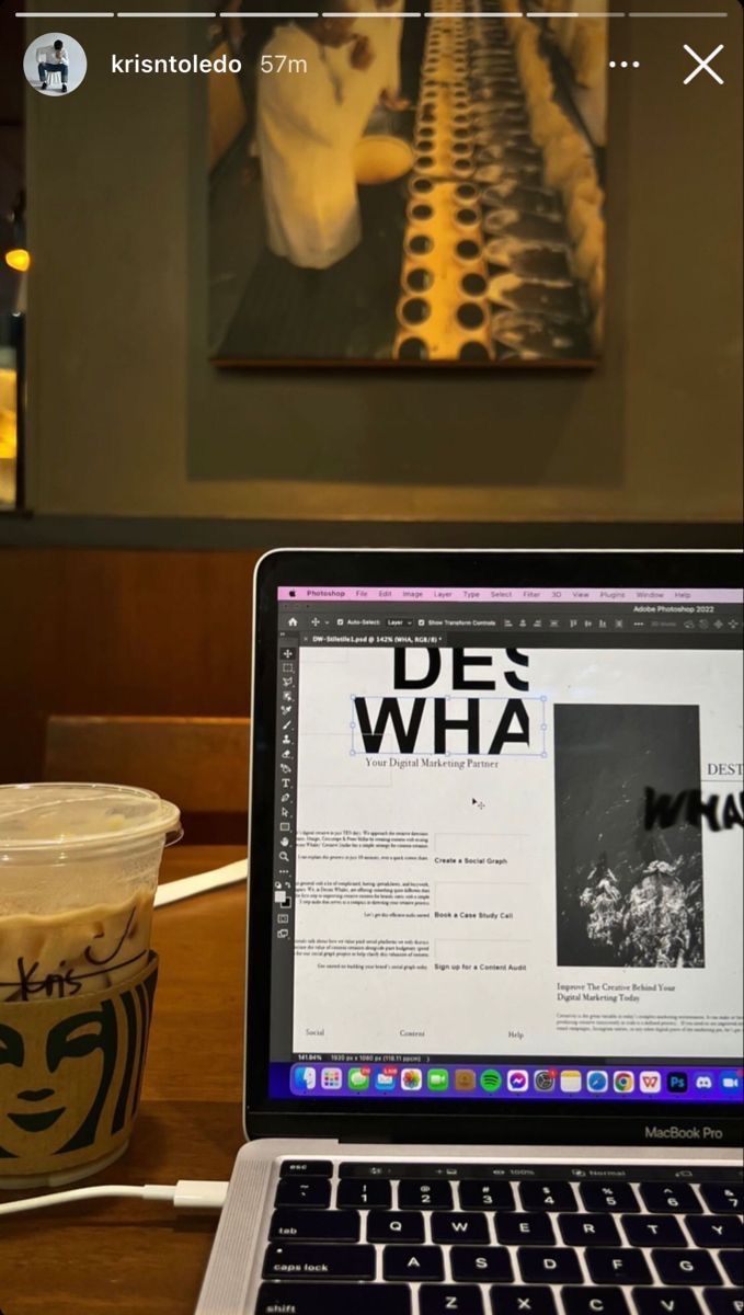 an open laptop computer sitting on top of a wooden table next to a cup of coffee