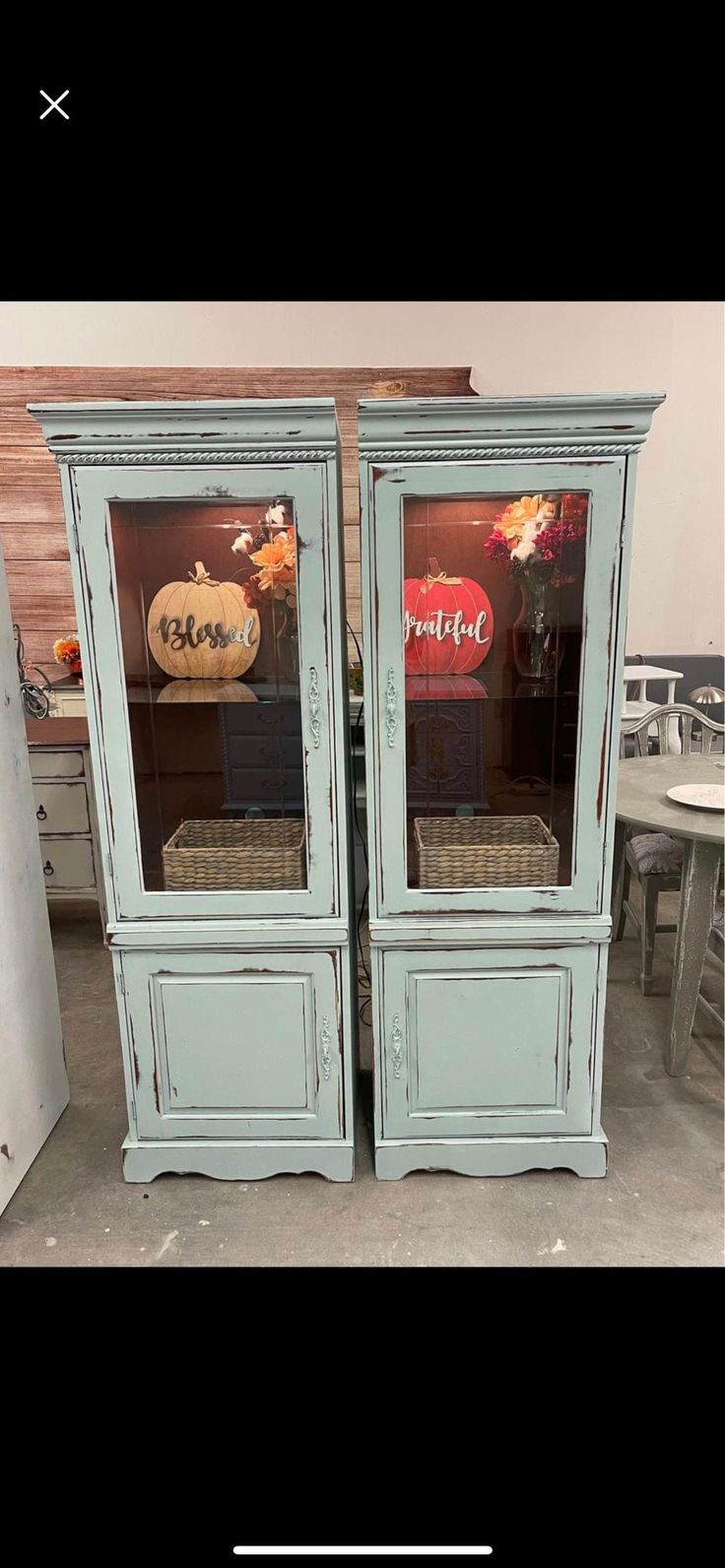 an old blue cabinet with two glass doors that are open to show the inside of it