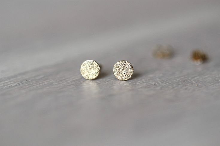 NEW FAVE ALERT! These adorable studs are perfect for every day wear and are lightweight, simple and classic. A great way to add understated style to any look! - Handcrafted glitter texture is added to the stud to give a bit of sparkle - Handcrafted out of 14K gold - Dot measures 5mm across - Choose between 14 yellow, 14K white or 14K rose gold - Comes with butterfly push backings - Dot is about .5mm thick - select in the drop down menu if you would like a single stud or a pair. Processing Times Gold Sparkling Minimalist Earrings, Minimalist Sparkling Gold Earrings, Studs Gold Earrings, Glitter Texture, Gold Dot, Studs Gold, Understated Style, Minimal Earrings, Dainty Studs