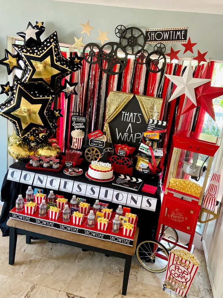 a table topped with lots of red and gold decorations next to a wall filled with stars