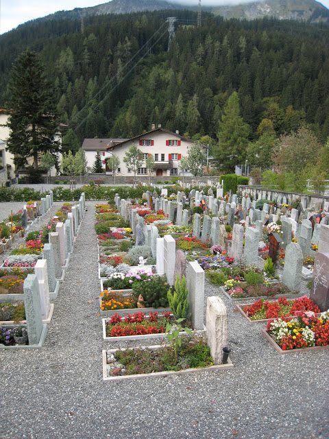 a cemetery with flowers in the middle and mountains in the backgrouds behind it