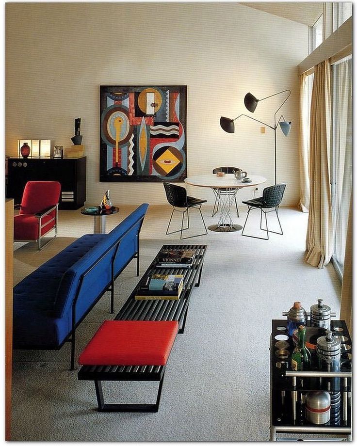 a living room filled with furniture and art on the wall next to a large window