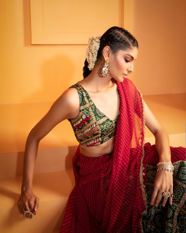 Introducing our striking Red Lehriya Drape Saree with Artsilk Bandhani and Shell detailing, accompanied by a Green Print Bandhani Blouse adorned with Shells and Fringes – a captivating ensemble that seamlessly merges traditional aesthetics with contemporary charm. Sari Blouse Design, Bandhani Blouse, Plain Chiffon Saree, Sari Blouse Designs, Saree Designs Party Wear, Drape Saree, Silk Kaftan, Sari Blouse, Chiffon Saree