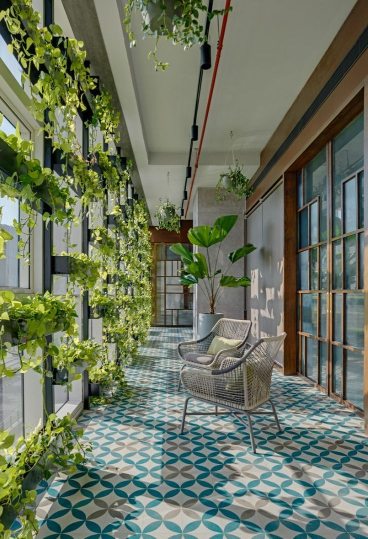 an outdoor patio with plants growing on the wall, and chairs in the foreground