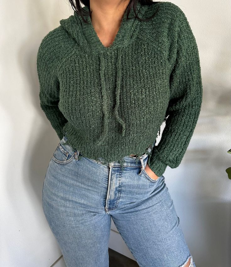 CROPPED HOODIE SWEATER GIVE YOUR EDGY STYLE SOME TRENDY UPGRADE!  SHOWCASING A KNITTED CONSTRUCTION THAT IS PERFECT FOR THE EARLY FALL SEASON, IT FEATURES A HOODED NECKLINE WITH DRAWSTRINGS AND LONG RAGLAN SLEEVES. THE LOOSE-FIT CROPPED BODICE ENDS AT A RAW EDGE HEM. 90% ACRYLIC / 10% POLYESTER MODEL IS  WEARING A SIZE SMALL Color:  HUNTER GREEN Small:2/4 Medium:6/8 Large: 10/12 FREE SHIPPING!! Comfy Winter Top With Drawstring Hood, Cozy Winter Top With Drawstring Hood, Trendy Green Hoodie Sweater, Cozy Hooded Tops For Cold Weather, Sporty Knit Hoodie For Fall, Trendy Stretch Sweater With Drawstring Hood, Cold Weather Hoodie Tops, Casual Cozy Fit Sweater With Drawstring Hood, Cozy Fit Soft Knit Hoodie For Winter