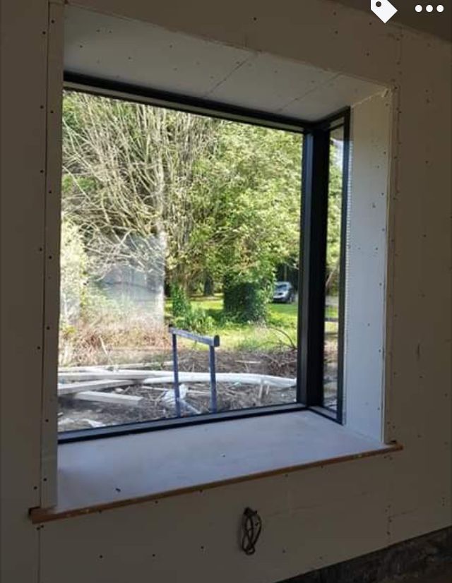 an empty room with a window that is missing the glass and some trees in the background