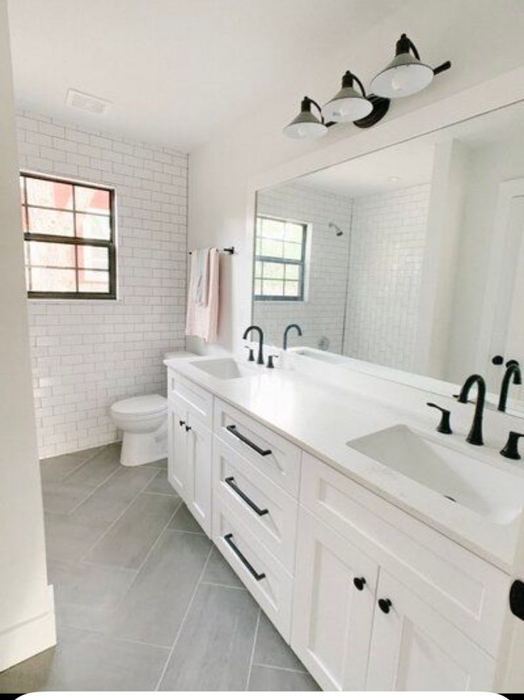 a white bathroom with two sinks and mirrors