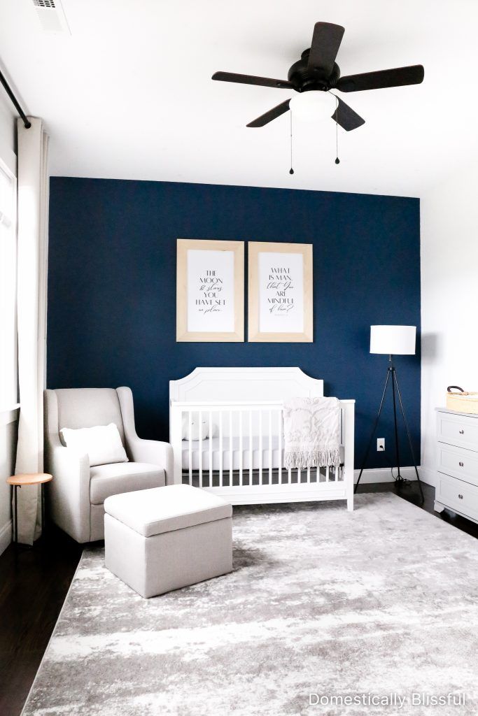 a baby's room with blue walls and white furniture