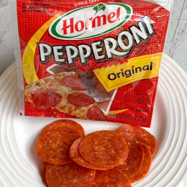 a bag of pepperoni sitting on top of a white plate