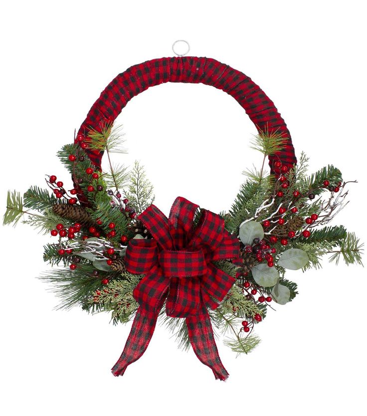 a red and black wreath with pine branches, berries and greenery tied around it