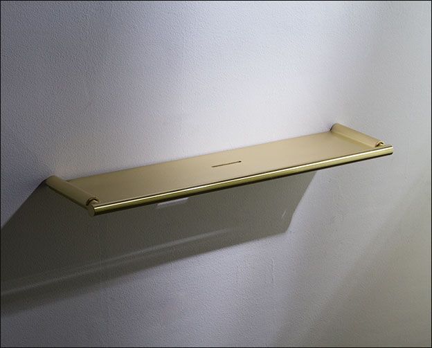 a gold shelf mounted to the wall with a light shining on it's side