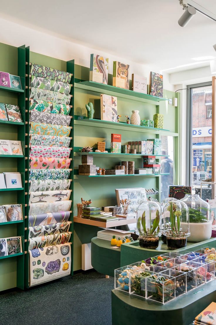 a store filled with lots of green shelves covered in cards and vases on top of them