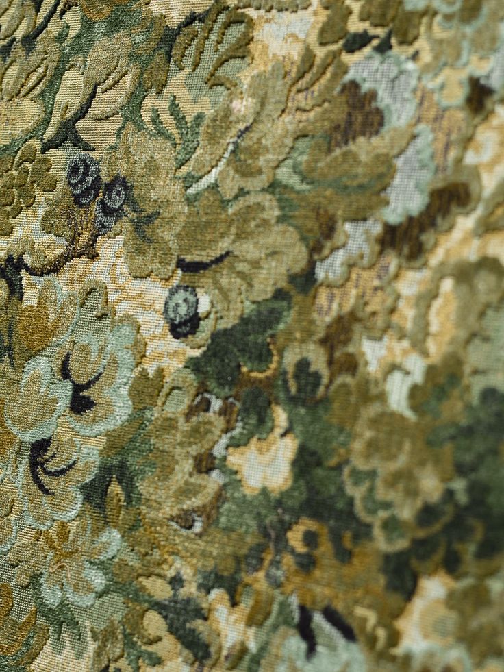 close up view of an intricately detailed floral design on a fabric with gold and green colors