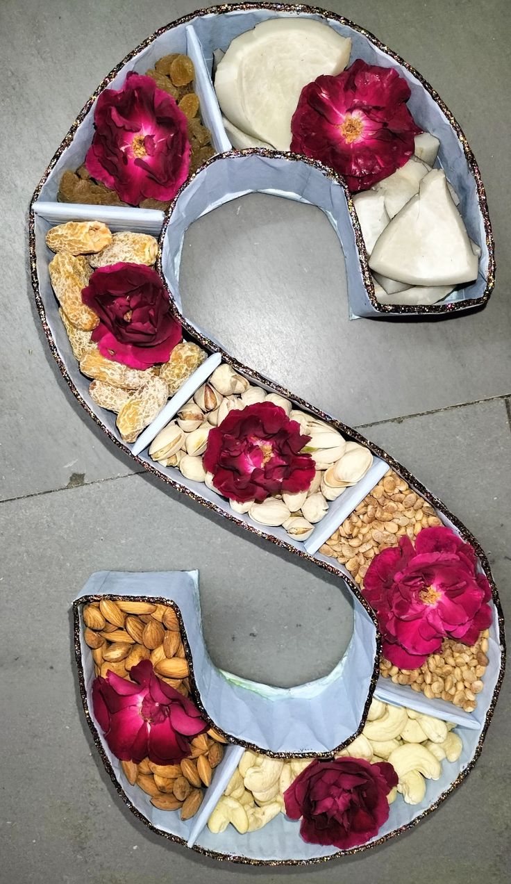 the letter s is decorated with flowers and nuts