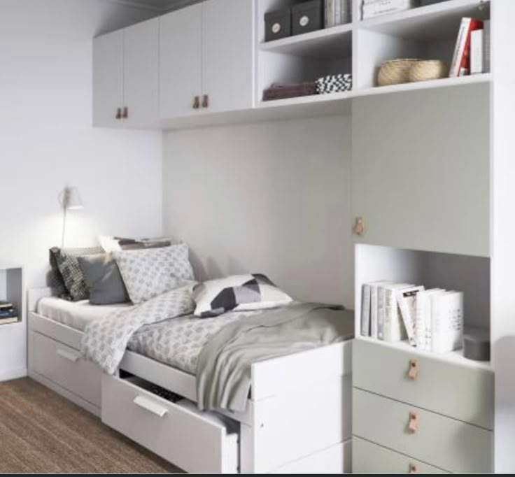 a bedroom with a bed, bookcases and drawers on the wall above it