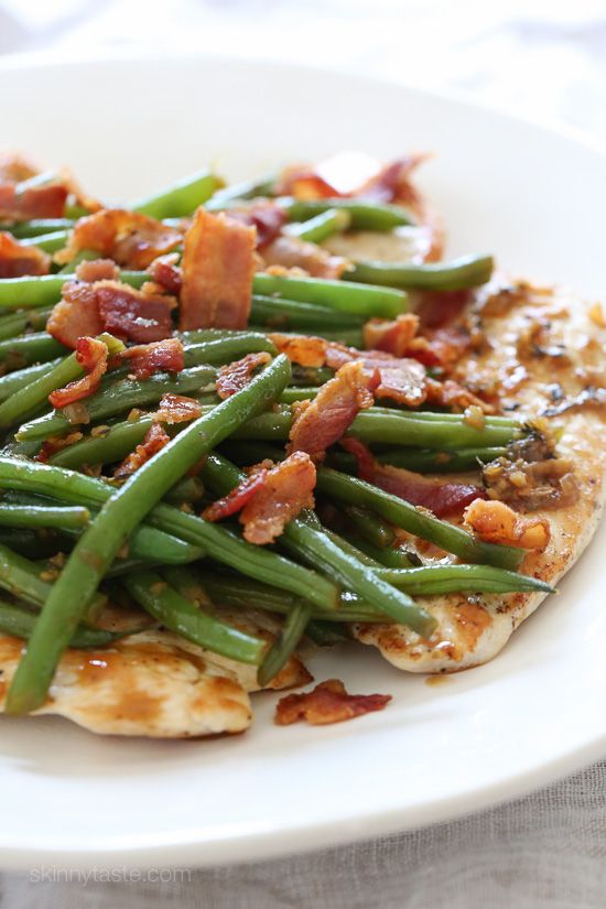 a white plate topped with green beans and bacon on top of pizza crust covered in sauce