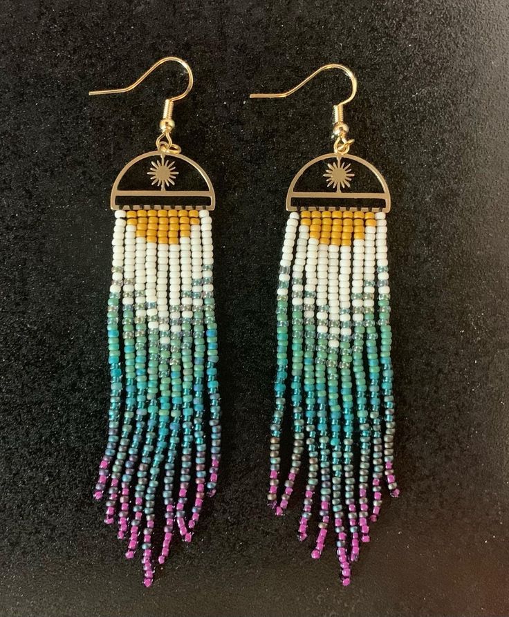 Purple, blue, green, white, and yellow dangly beaded earrings Adjustable Beaded Chain Earrings For Summer, Summer Beaded Chain Dangle Earrings, Multicolor Beaded Drop Earrings With Beaded Chain, Adjustable Chandelier Earrings With Colorful Beads, Rainbow Dangle Jewelry With Tiny Beads, Dangle Beaded Earrings For Beach, Beaded Chain Dangle Earrings For Beach, Multicolor Tiny Beads Drop Earrings, Bohemian Beaded Chain Earrings For Summer