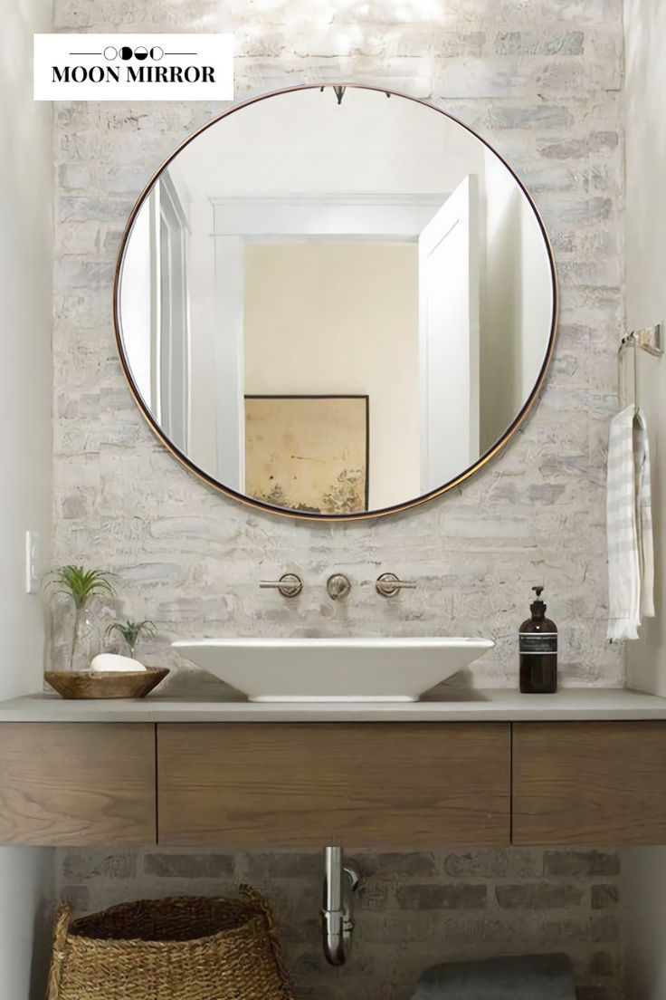 a bathroom sink with a mirror above it and a basket on the floor next to it