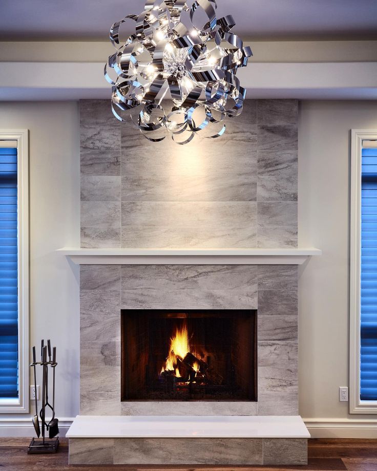 a living room with a fire place and a chandelier hanging from the ceiling