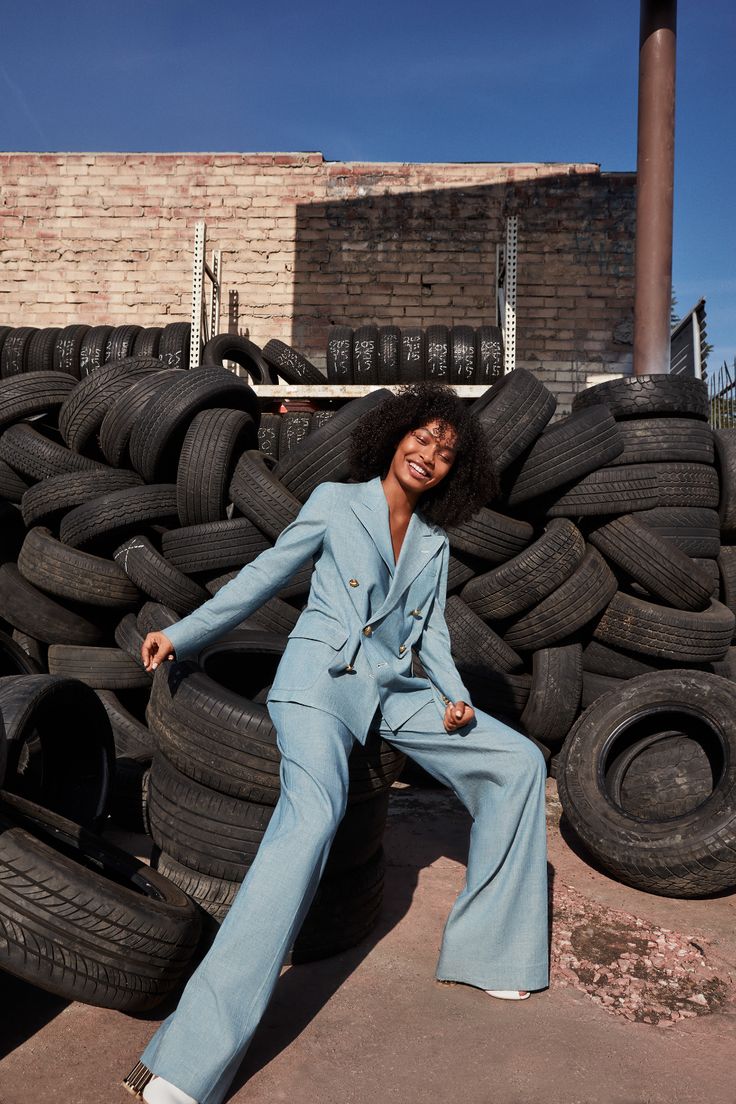 a woman sitting on top of a pile of tires