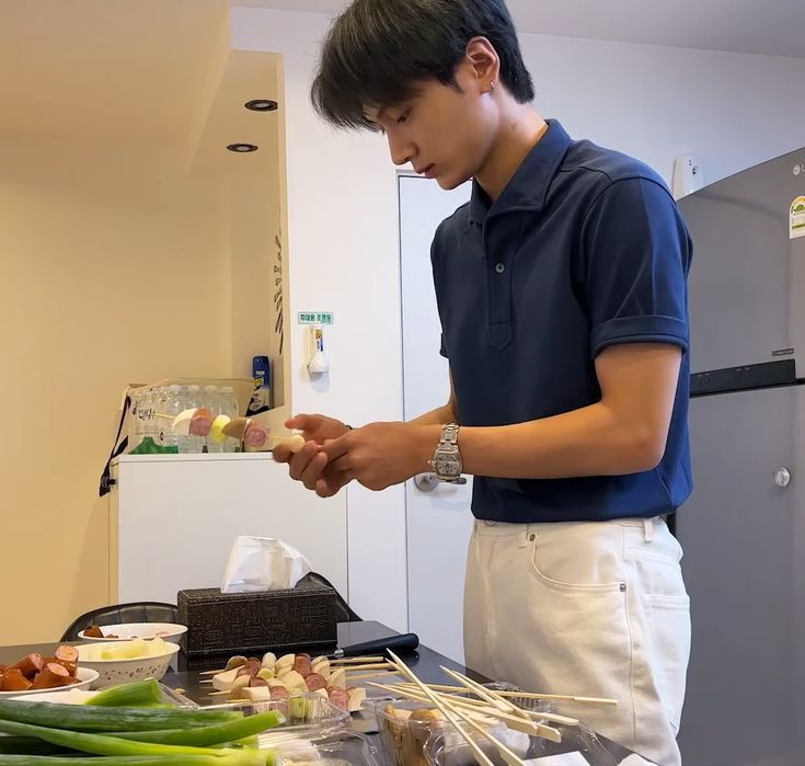 a young man preparing food on top of a table