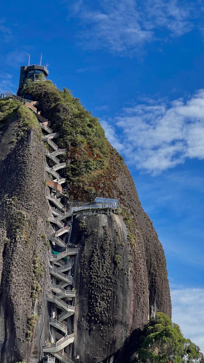 a very tall mountain with a spiral staircase going up it's side to the top