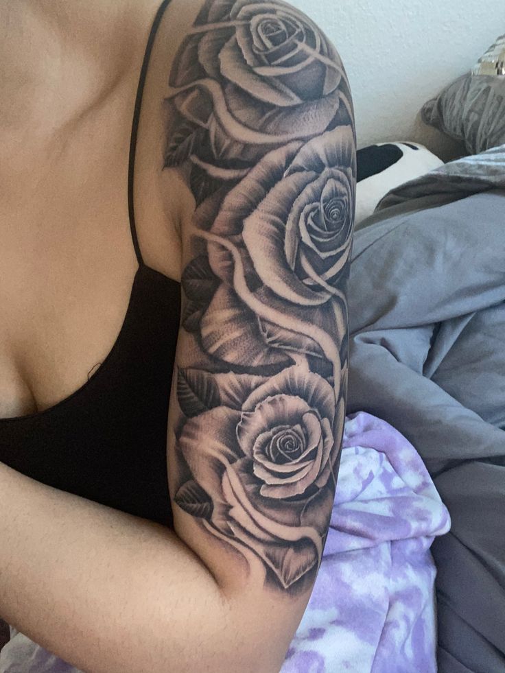 a woman with a black and white rose tattoo on her arm