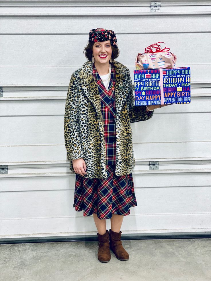 a woman in a leopard print coat holding up a box