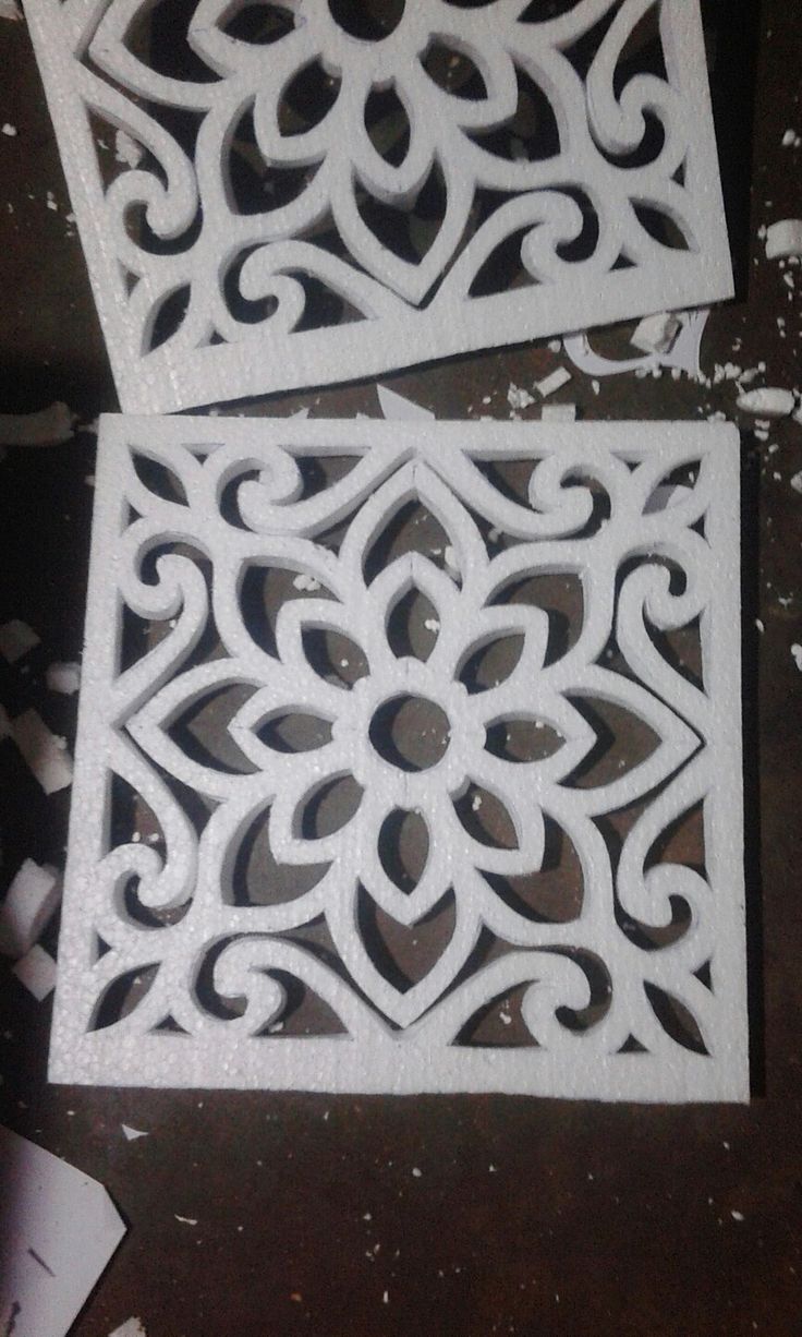 two white decorative tiles sitting on top of a table