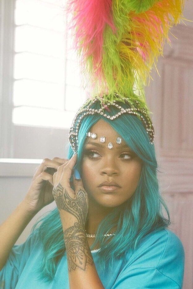 a woman with blue hair wearing a colorful headdress and feathers on her head