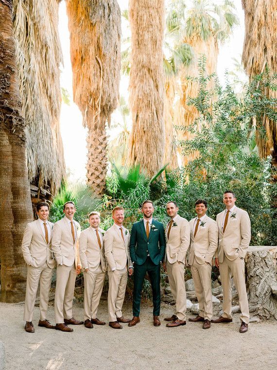 a group of men standing next to each other wearing suits and ties with palm trees in the background