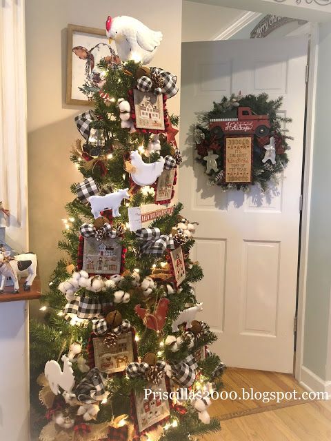 a decorated christmas tree in the corner of a room with pictures and ornaments on it