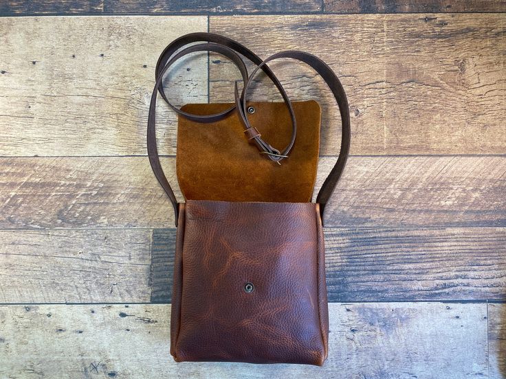 a brown leather bag sitting on top of a wooden floor