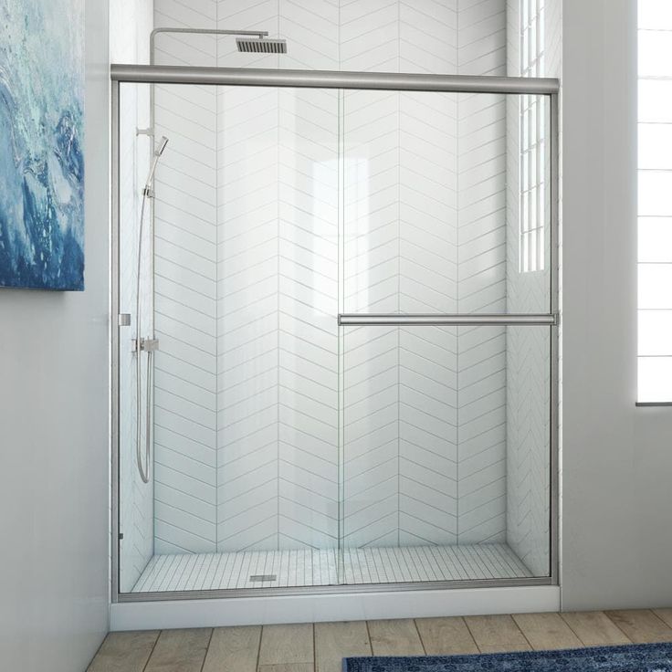 a bathroom with a blue rug and a shower door in the middle of the room