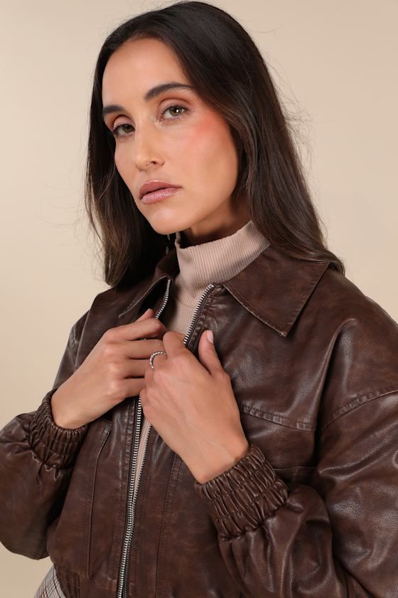 Hit the road looking cuter than ever in the Lulus Iconic Travels Brown Vegan Leather Cropped Bomber Jacket! Pebbled faux leather, with distressed fading throughout, shapes this stylish jacket with a collared neckline and long sleeves with drop shoulders and fitted elasticized cuffs. An exposed silver zipper secures at the front of the cropped bodice that boasts two, seamed zippered front pockets. Classic, elasticized banded hem completes the look. Pair with the matching skort for a complete look Trendy Leather Jacket With Padded Collar For Fall, Trendy Biker Jacket With Padded Collar For Fall, Trendy Collared Biker Jacket For Fall, Brown Collared Leather Jacket For Spring, Brown Leather Jacket With Padded Collar For Spring, Fall Brown Biker Jacket With Padded Collar, Trendy Faux Leather Collared Jacket, Distressed Brown Long Sleeve Outerwear For Fall, Retro Distressed Brown Leather Jacket For Fall