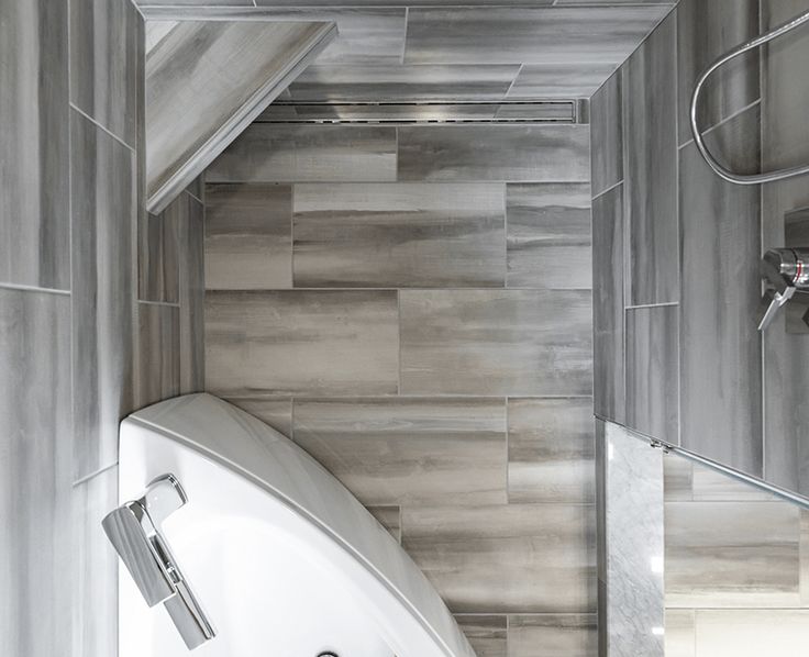 a white bath tub sitting under a bathroom mirror